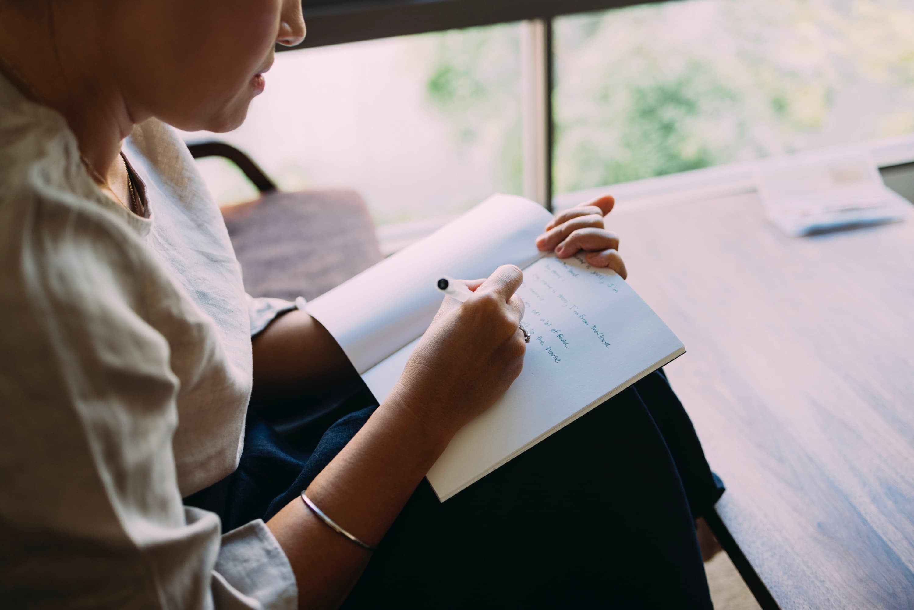 Closeup of woman's hand holding a pen and writing in a
notebook